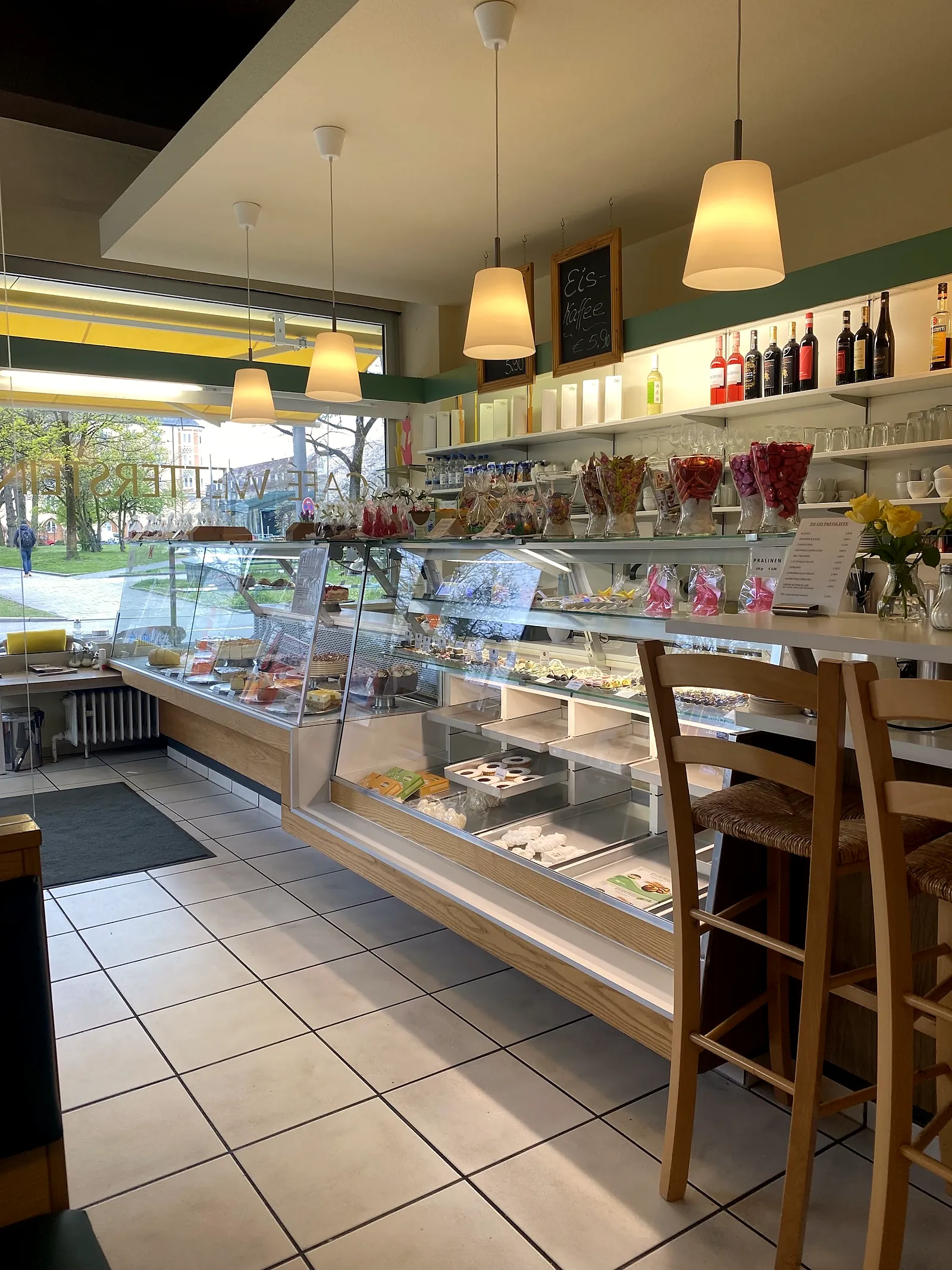 Gastraum mit Vitrine, Theke, Hängeleuchten und Weinregal