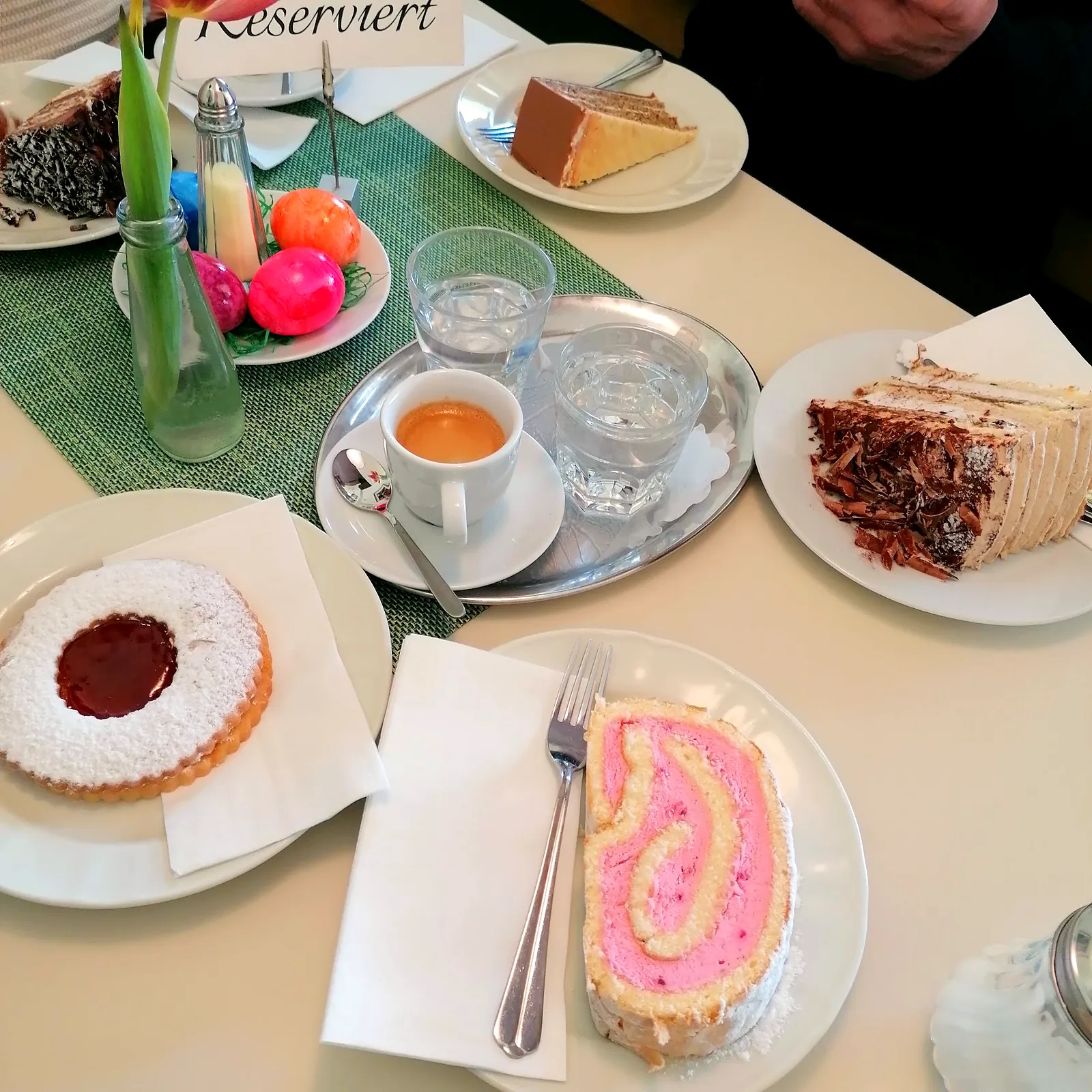 Biskuitrolle, Linzer Plätzchen und Tee am Tisch