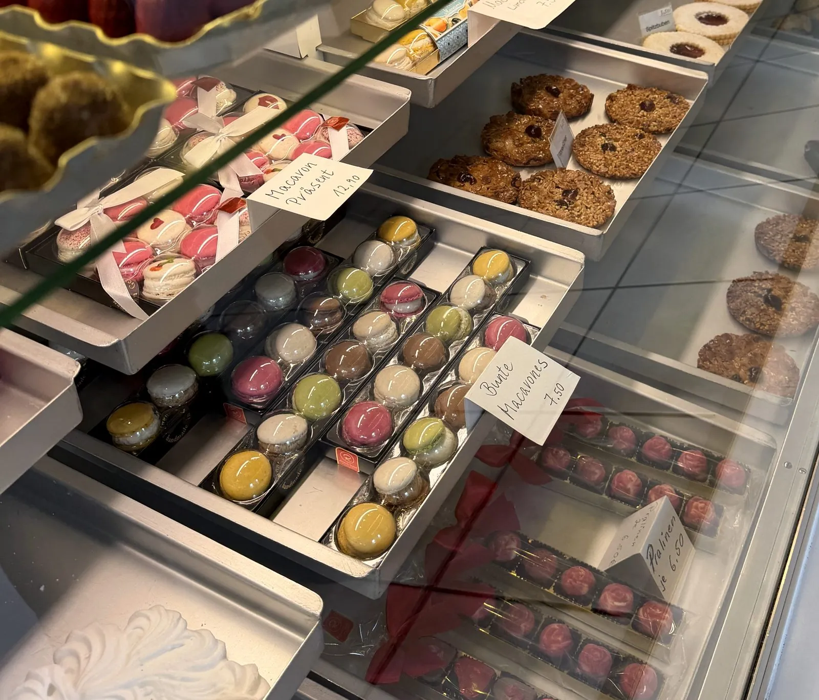 Bunte Macarons und Macaron-Präsent in der Vitrine