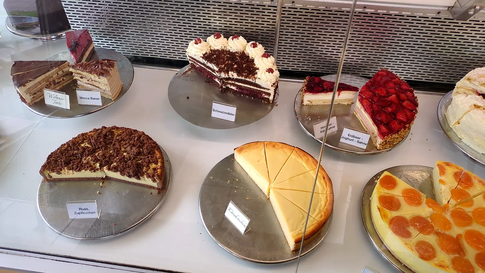 Sahnetorten, Käsekuchen und Aprikosenkuchen in der Vitrine
